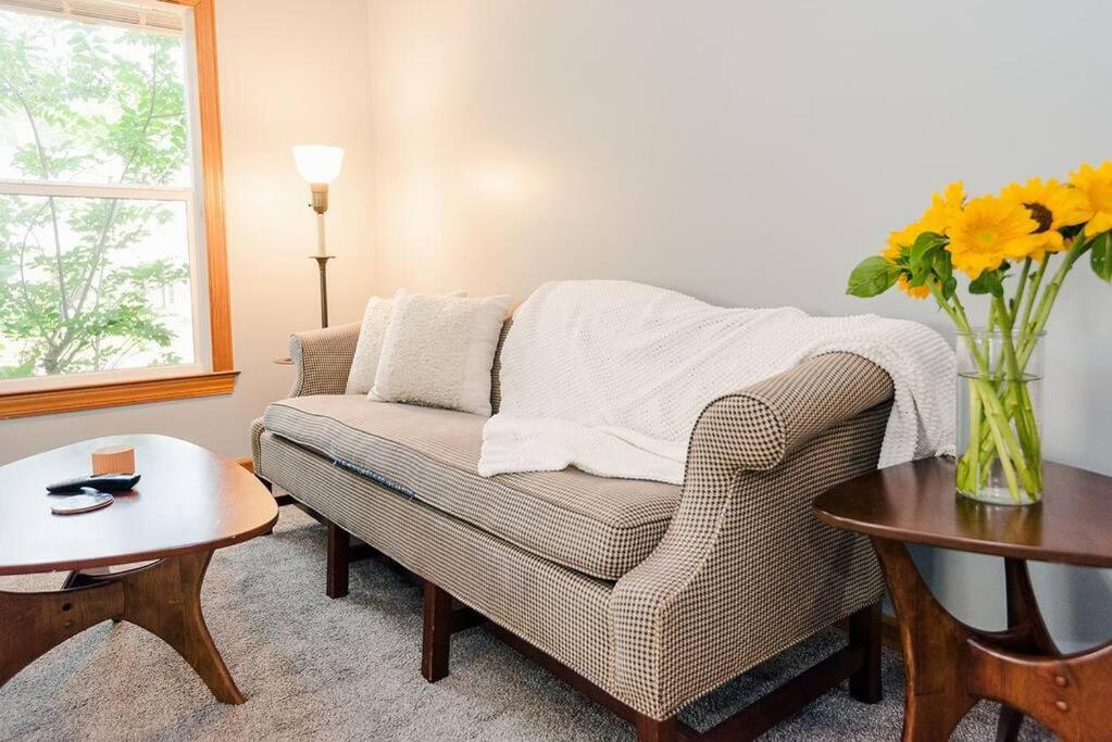 a living room with a couch and a vase of flowers at Kinston Getaway #1 in Kinston