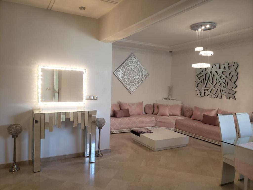 ein Wohnzimmer mit einem rosa Sofa und einem Tisch in der Unterkunft Luxurious apartment in Fès
