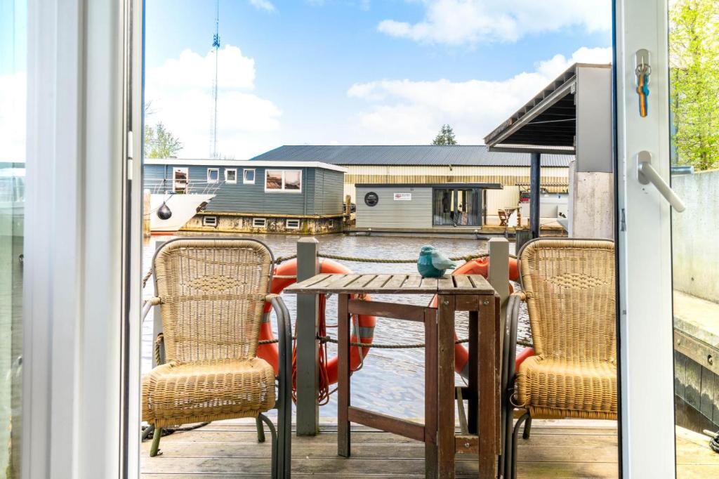 een patio met een tafel en stoelen op een balkon bij Charming and cozy Houseboat near Giethoorn in Zwartsluis