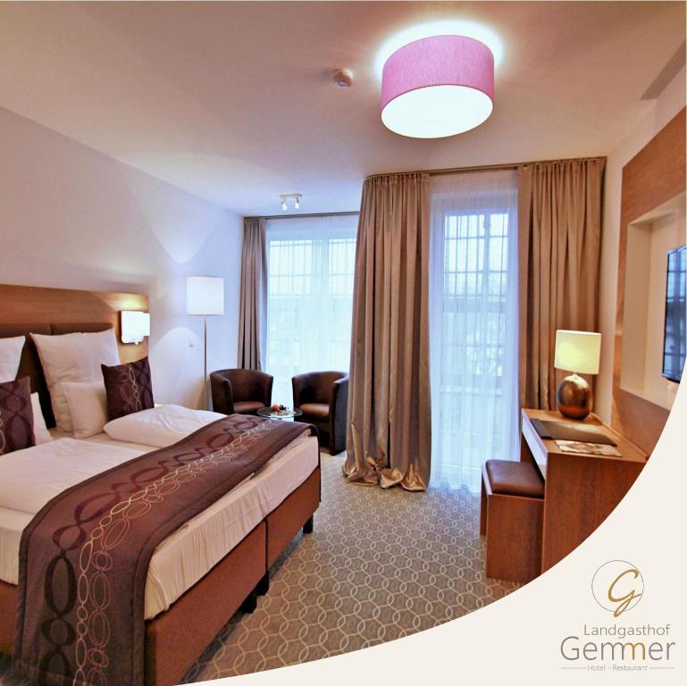 een hotelkamer met een groot bed en een bureau bij Hotel Landgasthof Gemmer in Rettert