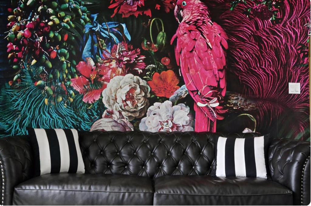 a black leather couch in front of a colorful wall at Stunning Designer Apartment in the Hills in Glendale