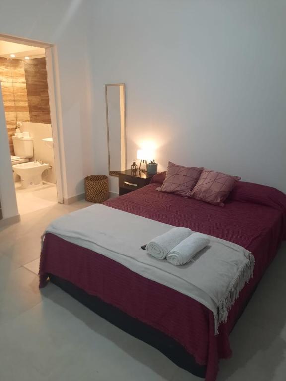 a bedroom with a large bed with two towels on it at Tu Refugio 3 - Monoambiente/Loft cerca del parque in Santiago del Estero