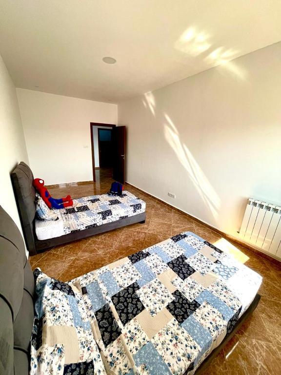 2 camas en una habitación con edredón en el suelo en Residence guessab, en Orán