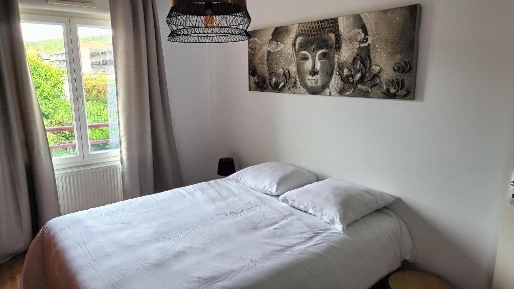 łóżko w sypialni z obrazem na ścianie w obiekcie Le gîte des Prémontrés w mieście Pont-à-Mousson