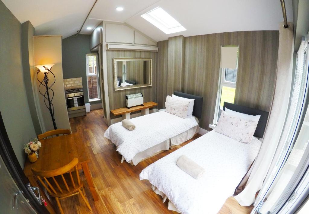 1 dormitorio con 2 camas, mesa y escritorio en Golilli Studio Accommodation Clare, en Newmarket on Fergus