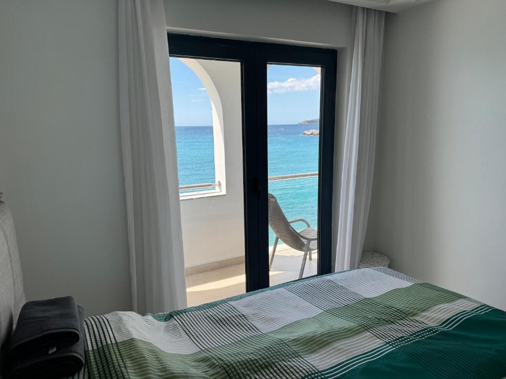 a bedroom with a bed and a view of the ocean at Beach apartment Sveti Stefan in Sveti Stefan