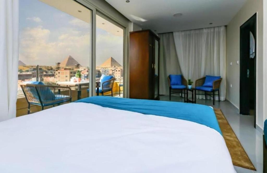 a bedroom with a bed and a view of the pyramids at Diamond Pyramids View Inn in Cairo