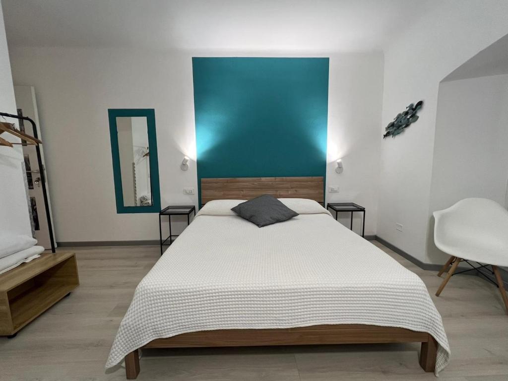 1 dormitorio con cama y pared azul en I Profumi del Mare en La Spezia
