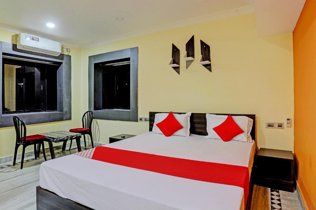ein Hotelzimmer mit einem Bett, einem Tisch und Stühlen in der Unterkunft Flagship VENTURE INN GUEST HOUSE in Bhubaneshwar