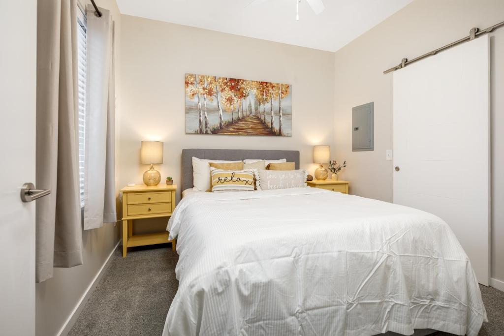 a bedroom with a white bed and a painting on the wall at Cute Condo TART Trail Bikes AC Downtown in Traverse City