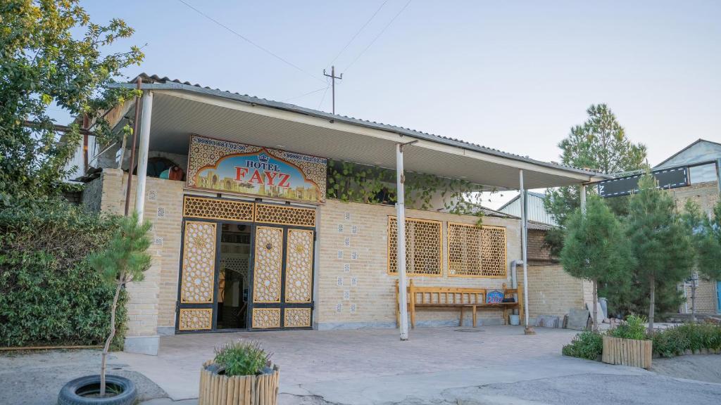 un restaurante de comida rápida con un banco fuera de él en Fayz, en Bukhara