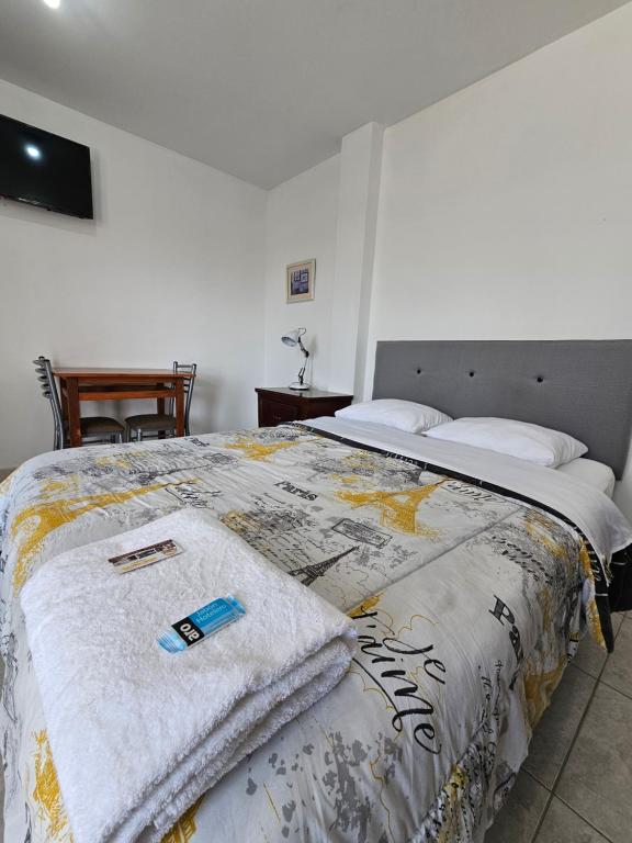 Un dormitorio con una cama con una manta. en Hospedaje Las Parraz en Ica