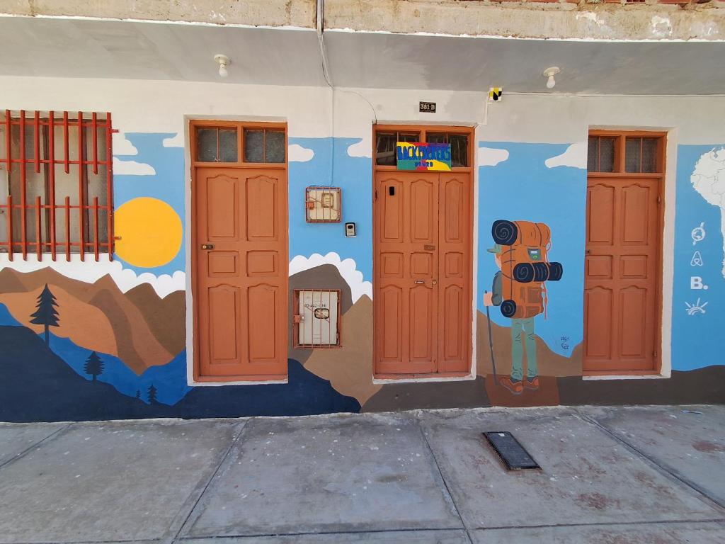 un mur orné d'une fresque murale représentant les portes d'un bâtiment dans l'établissement Backpacker Oruro, à Oruro