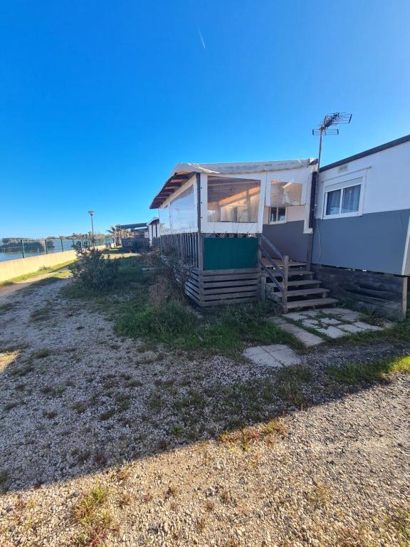 une maison sur la plage avec l'océan en arrière-plan dans l'établissement Mobil-home au Camping Bleu Marine, à Sérignan