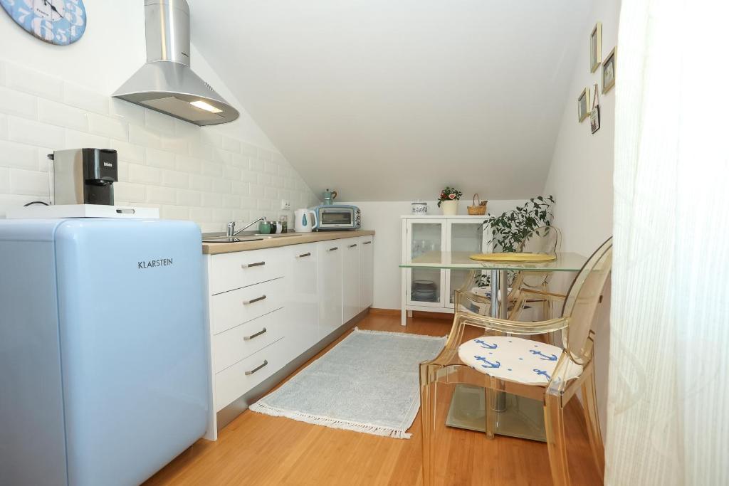 una cucina con frigorifero e tavolo con sedie di Z&A Studio apartment with parking a Božava