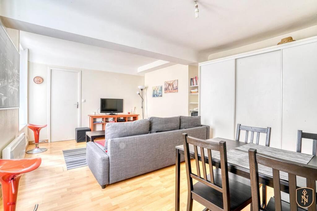 un salon avec un canapé et une table dans l'établissement Peaceful apartment in the heart of Caen, à Caen