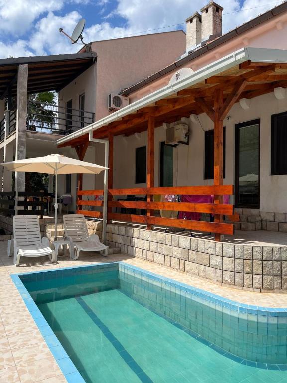 a house with a swimming pool in front of a house at GRAMISI apartments in Kruče