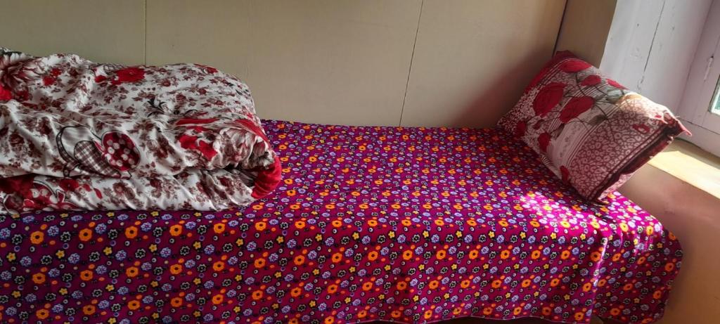 KhumjungにあるTrekkers Lodgeの赤と白の掛け布団が備わるドミトリールームのベッド1台分です。