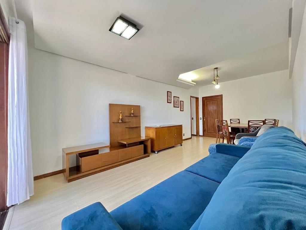 uma sala de estar com um sofá azul e uma mesa em Residencial Porto Fino em Caxias do Sul