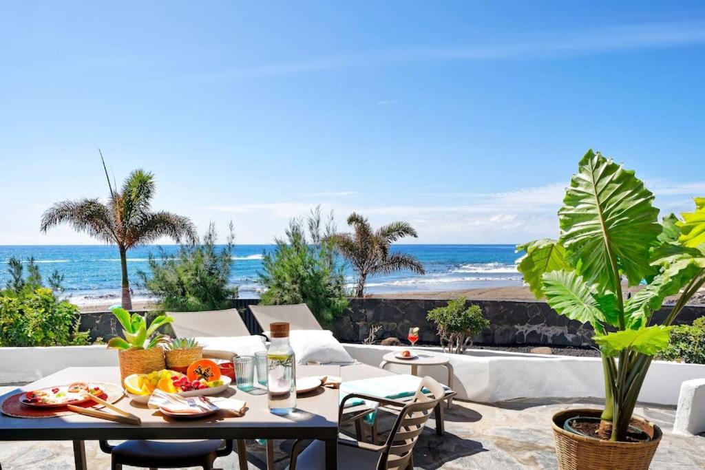 a patio with a table and chairs and the ocean at Amapola Palms - recién reformado, frente al mar in San Agustin