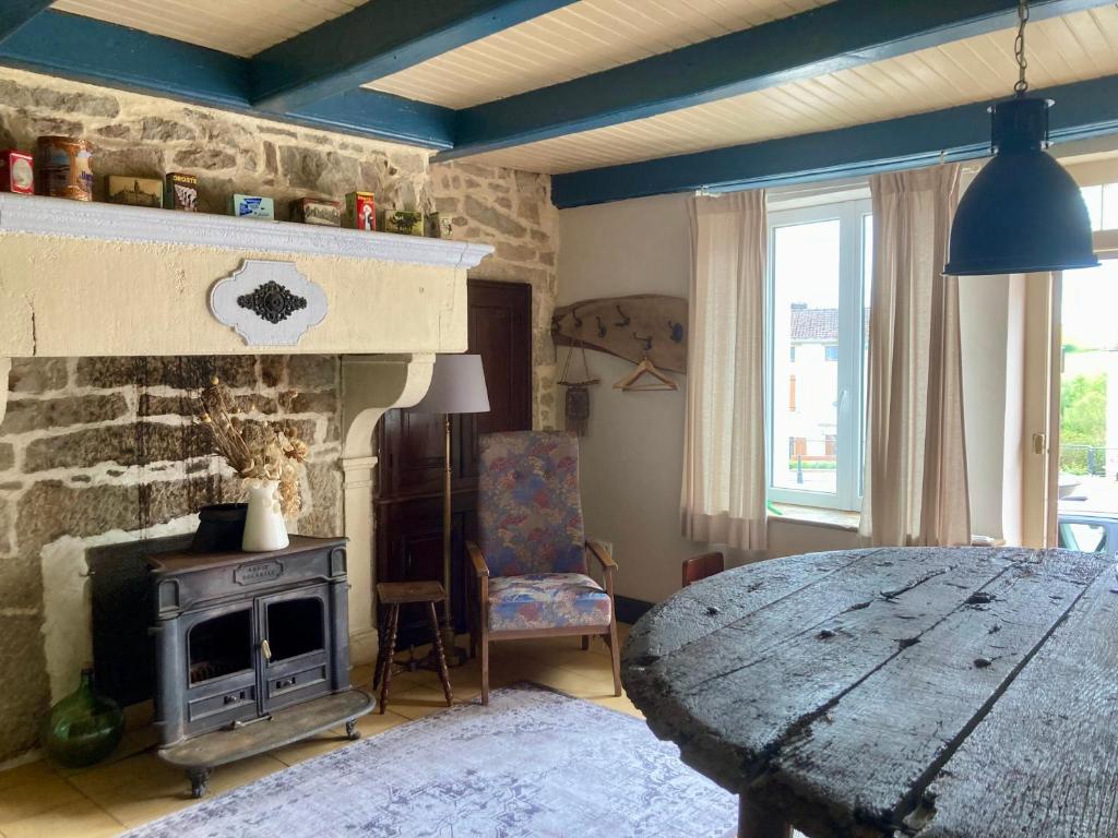 appartement L'Atelier in Isches في Isches: غرفة معيشة مع موقد حجري وطاولة