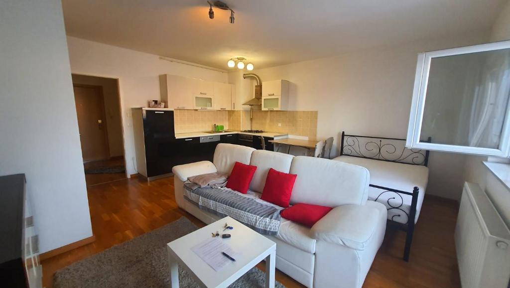 sala de estar con sofá blanco y almohadas rojas en MINIMI 2, en Zagreb