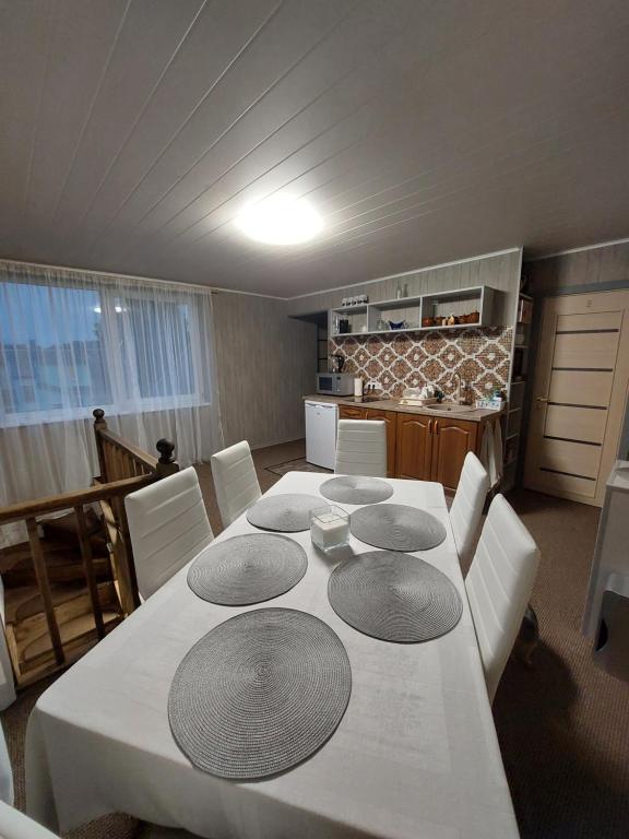 a dining room with a white table and white chairs at Dariaus ir Gireno 7 in Zarasai