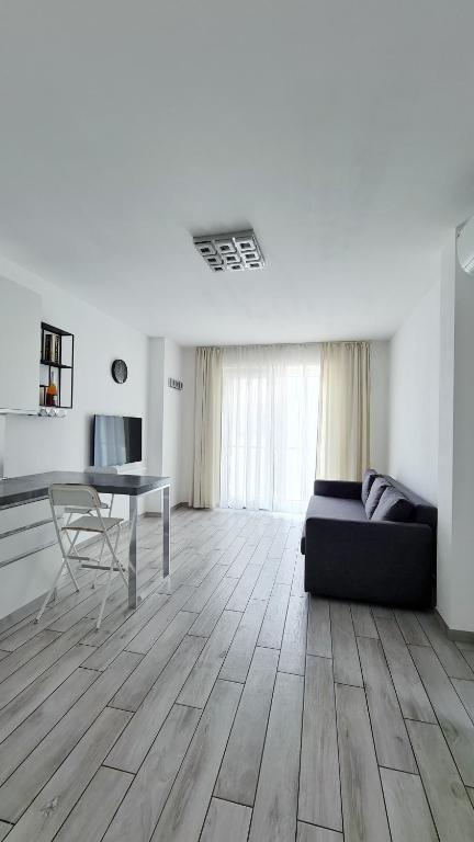 a living room with a black couch and a table at Severis Apartment Fiumicino in Fiumicino