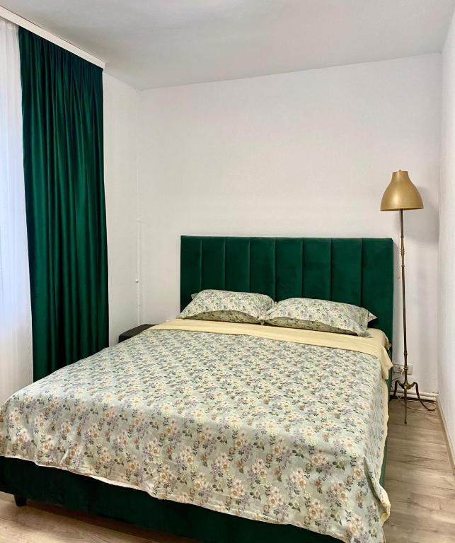 een bed met een groen hoofdeinde in een slaapkamer bij Mainstreet Apartments Suceava in Suceava