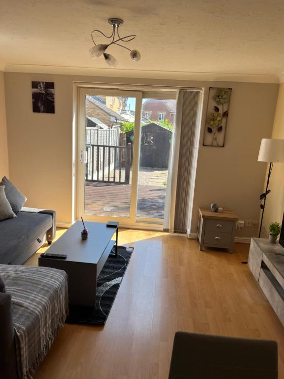 a living room with a couch and a table at Stylish 2 Bedroom Home In Essex in Basildon
