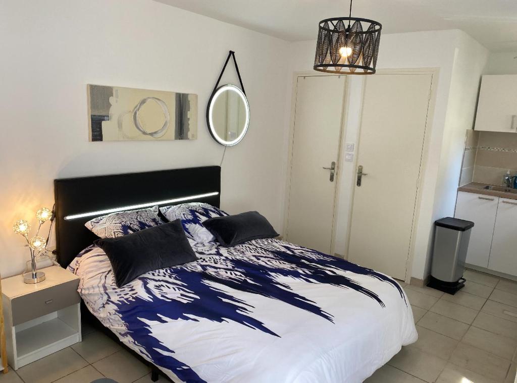 Schlafzimmer mit einem Bett und einem Wandspiegel in der Unterkunft Superbe et sympa in Neuilly-Plaisance