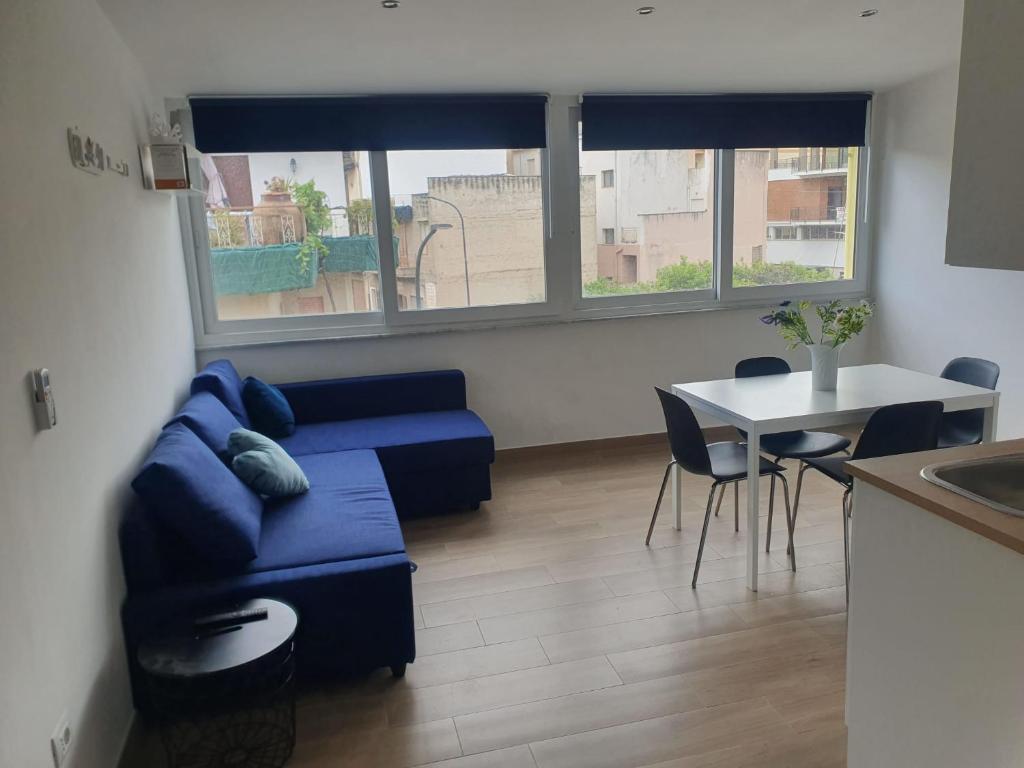 a living room with a blue couch and a table at GIANGY HOME in Casteldaccia