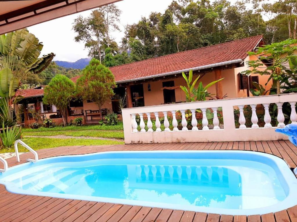 a swimming pool in front of a house at Pouso bom retiro in Paraty
