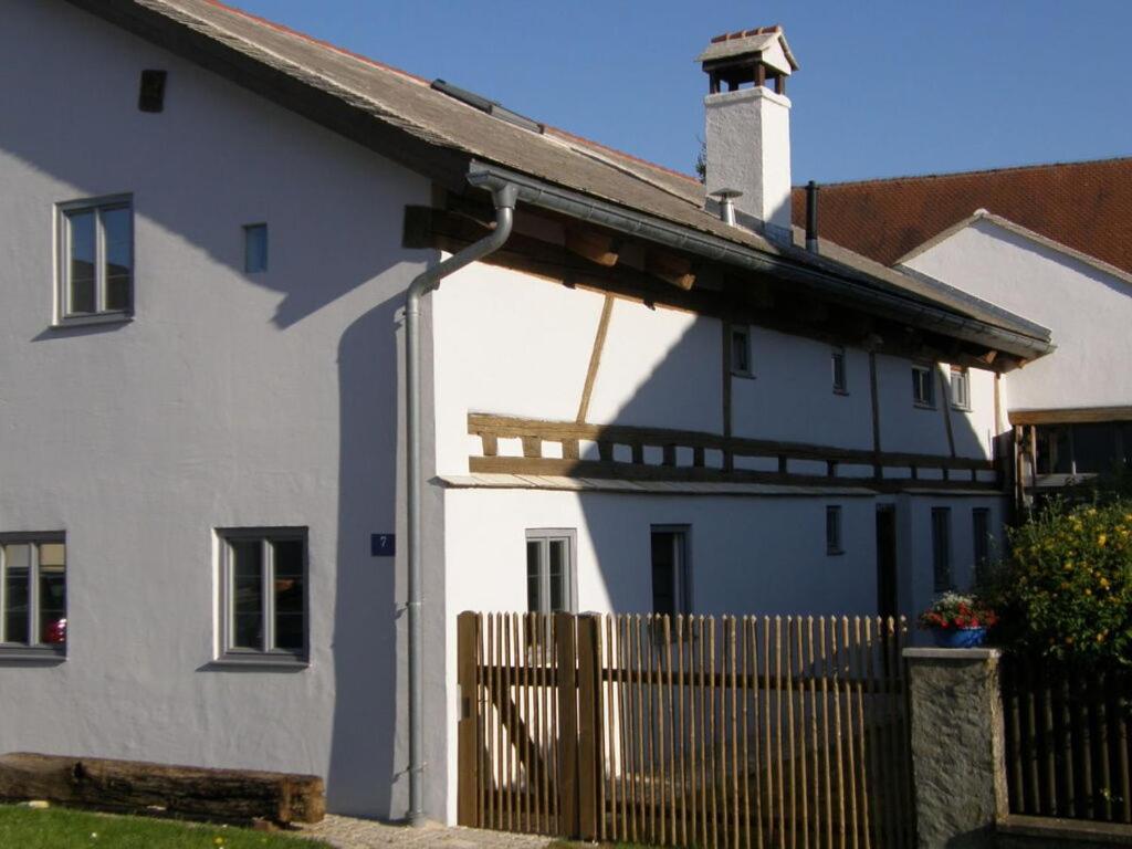 une maison blanche avec une clôture en bois devant elle dans l'établissement "Zum Kirchenschuster", à Schernfeld