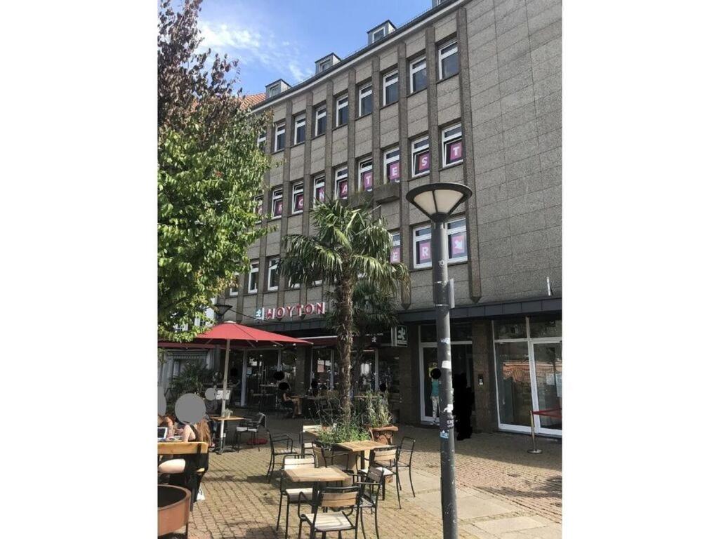 una calle vacía con mesas y sillas frente a un edificio en Holiday Apartment 2 Oldenbug en Oldenburg