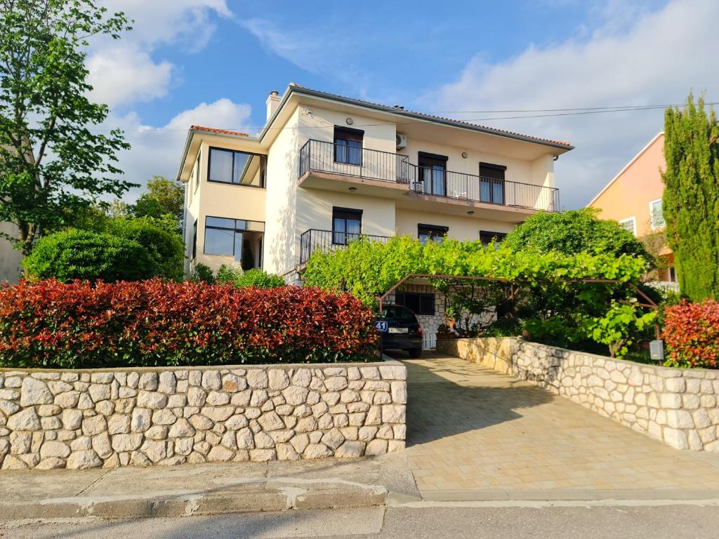 a house with a stone wall in front of it at APARTMAN MARKO 2 in Novi Vinodolski