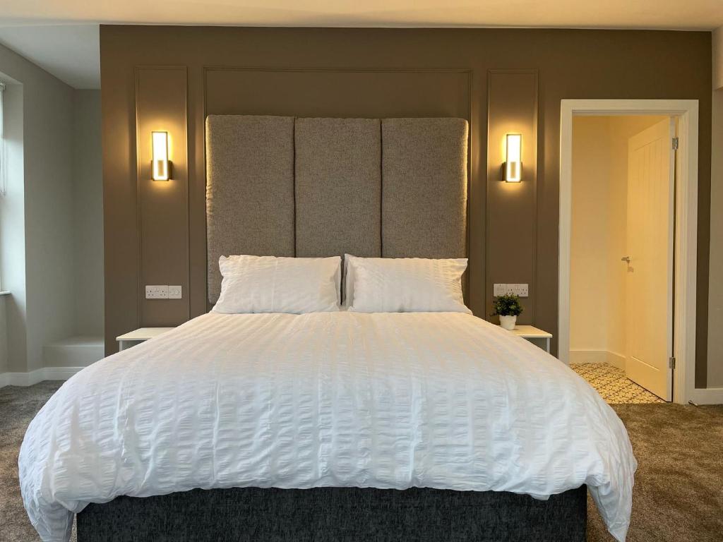 ein Schlafzimmer mit einem großen weißen Bett mit zwei Leuchten in der Unterkunft Wellington house in Blythe