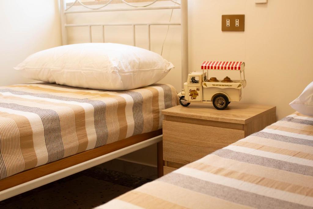 um quarto com duas camas e uma van de brinquedo em uma mesa de cabeceira em Una rosa sul mare Monopoli em Monopoli