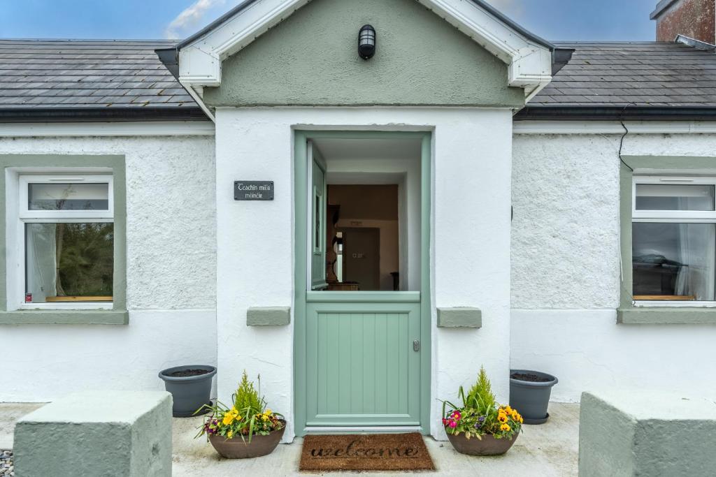 een huis met een groene deur en twee ramen bij Teachin milis Moineir in Boyle