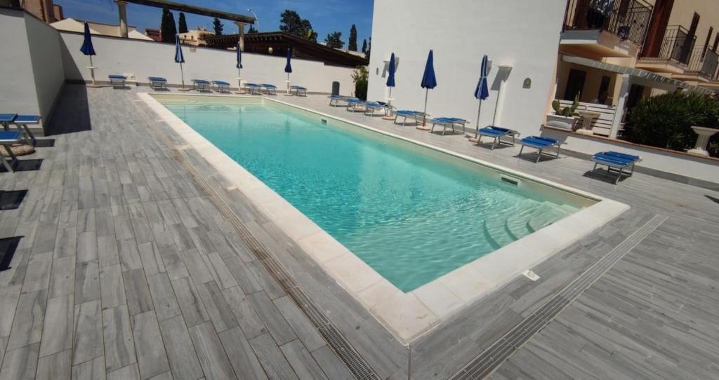 una piscina con sedie e un edificio di holiday home LG a San Vito lo Capo