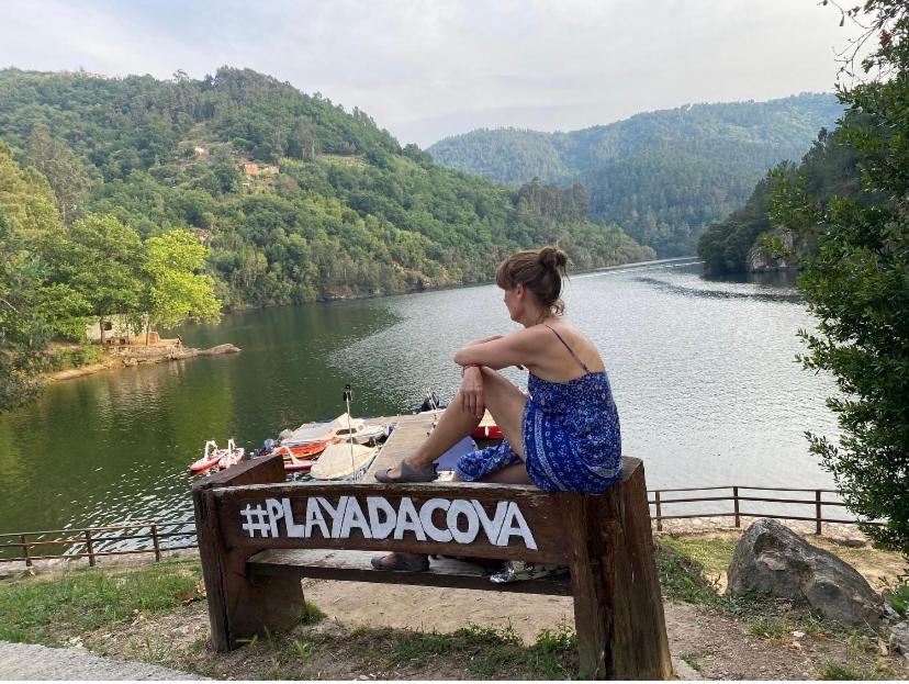 Una donna seduta su una panchina vicino a un fiume di TU REFUGIO RIBEIRA SACRA consulta descripción anfitrión a Lugo