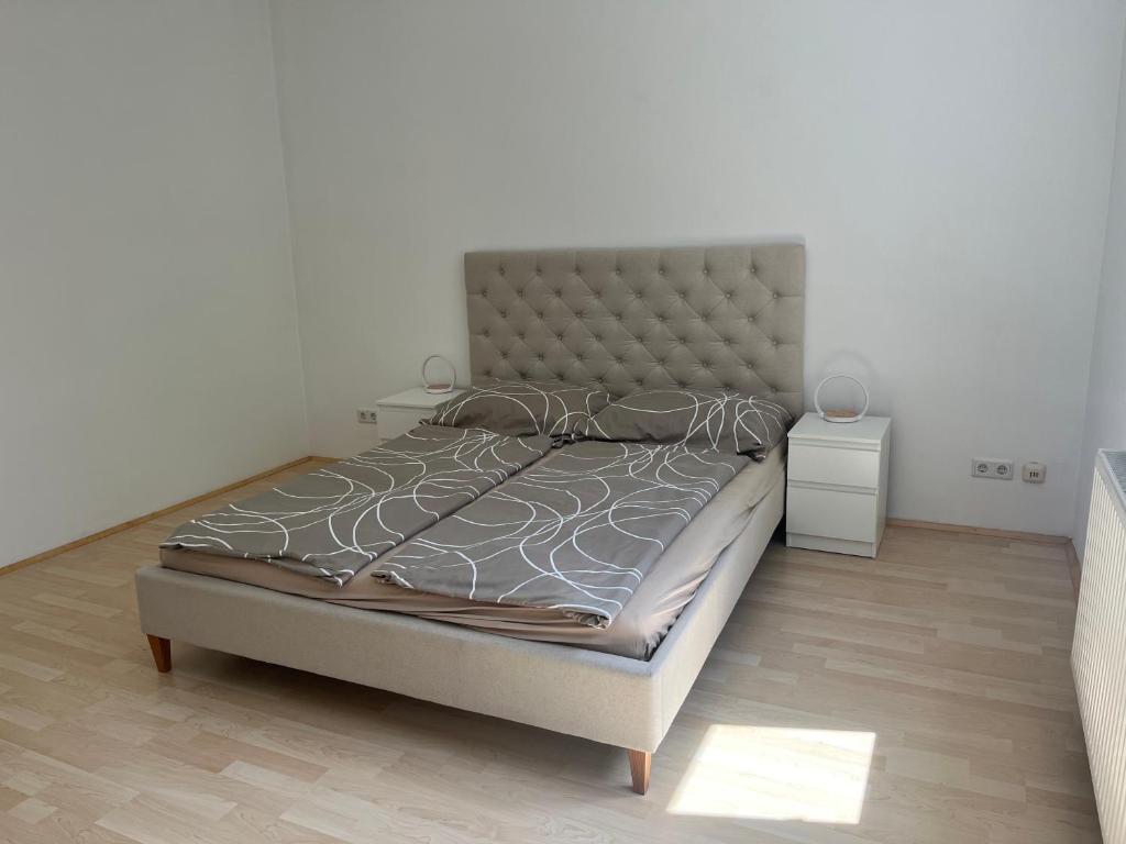 ein Bett in einem Schlafzimmer mit einer weißen Wand in der Unterkunft Traumgarten in Traumlage - 25 Minuten ins Zentrum in Wien