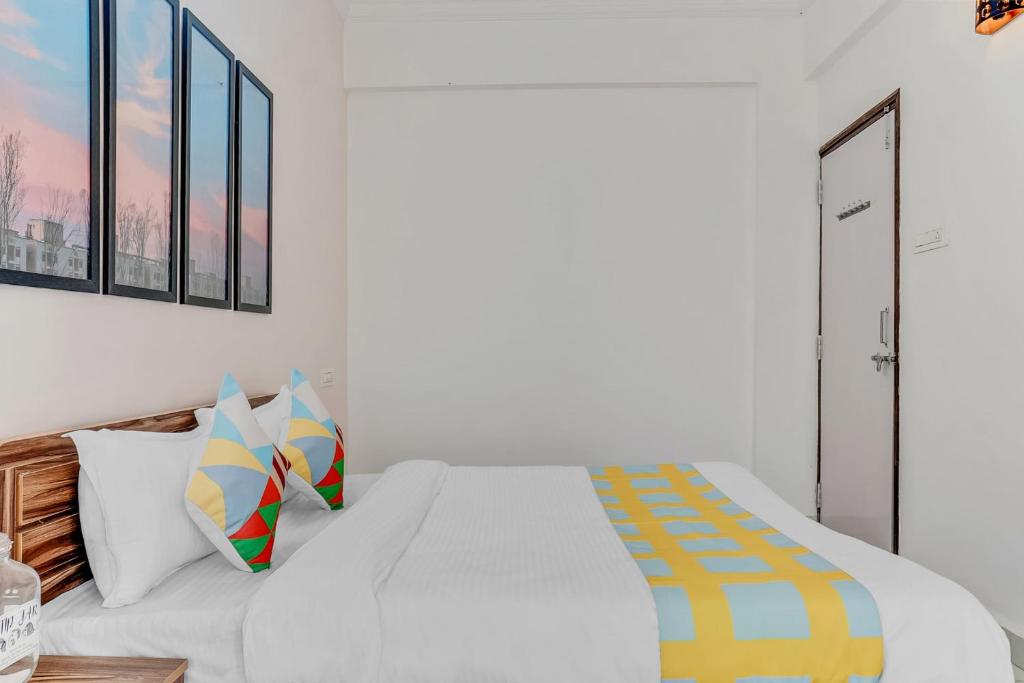 a white bedroom with a white bed and some windows at OYO Home Dazzling Studios Near Airport Near Pune Airport in Lohogaon