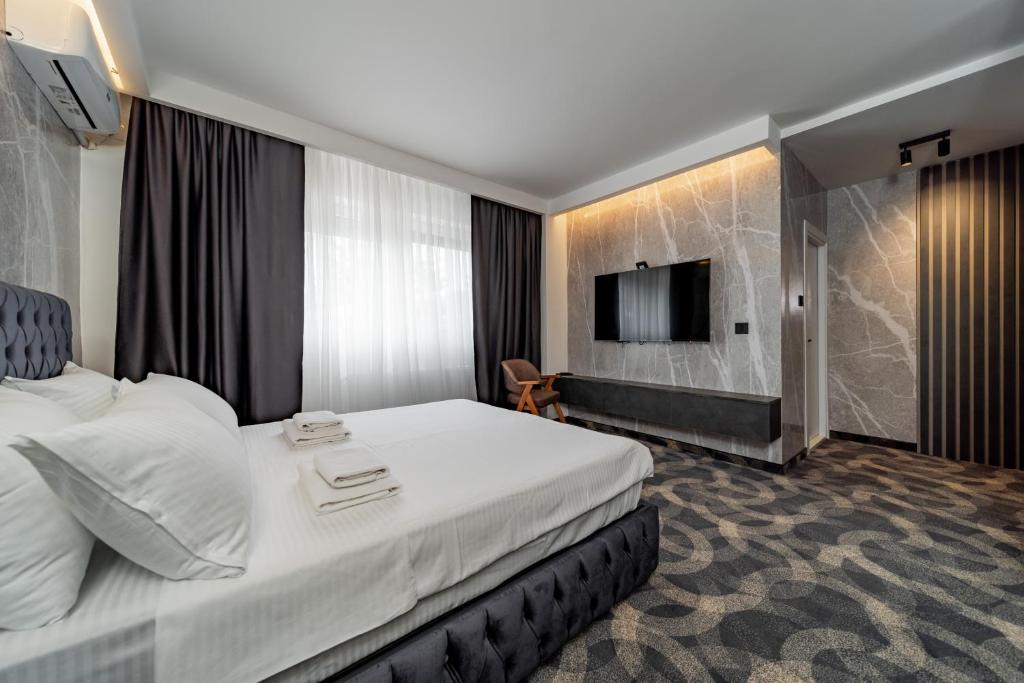 a hotel room with a bed and a flat screen tv at Apartmani 8 Beograd in Jajinci