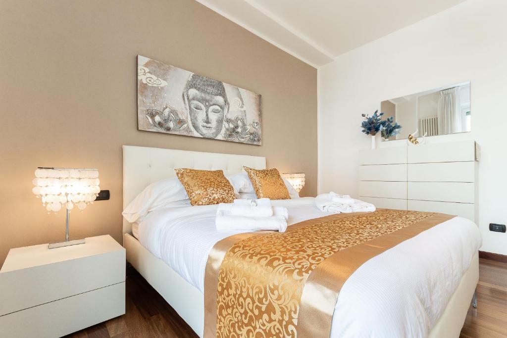 - une chambre avec un grand lit blanc et une lampe dans l'établissement Nest of Elegance - 5 minuti dalla stazione -, à La Spezia