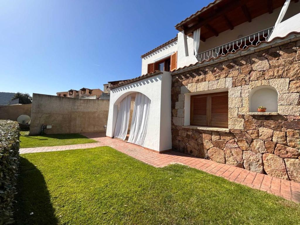 een stenen huis met een poort en een stenen muur bij Casa vacanze - Le Bacche di Maiorca in Budoni