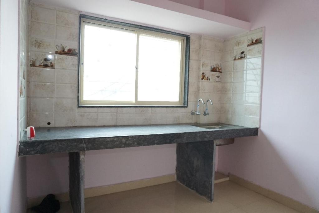 baño con lavabo de piedra grande y ventana en SPOT ON Hotel Aryan Lodging And Boarding, en Chākan