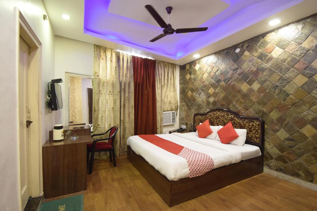 Super OYO Hotel Maa Residency في جامو: غرفة في الفندق سرير مع مروحة سقف