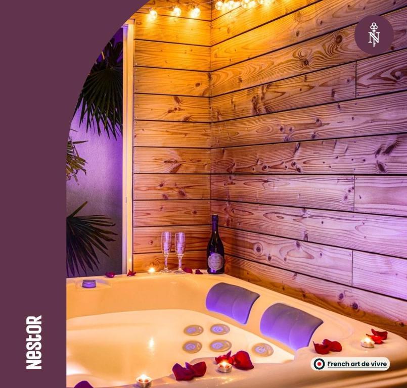 eine Badewanne in einem Zimmer mit einer Holzwand in der Unterkunft Casa Gauda — Jacuzzi, relaxation & serenity in Falaise