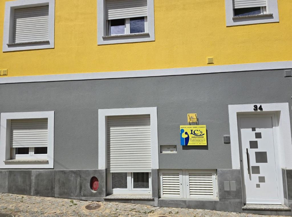 un edificio giallo e grigio con un cartello sopra di LC's Guesthouse a Lagos